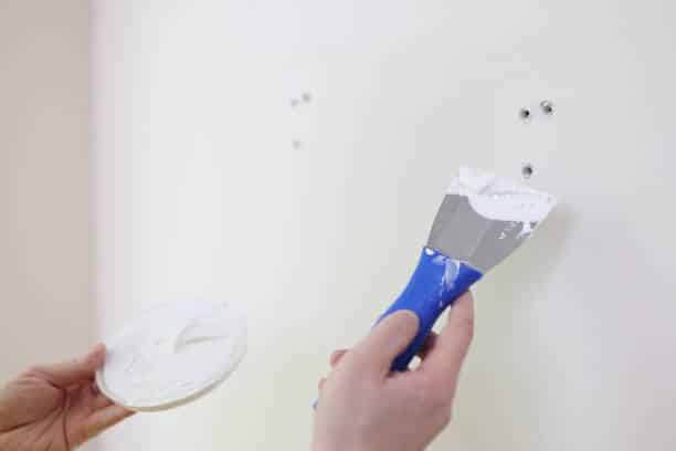 Rebouchage de trous dans un mur avec de l’enduit