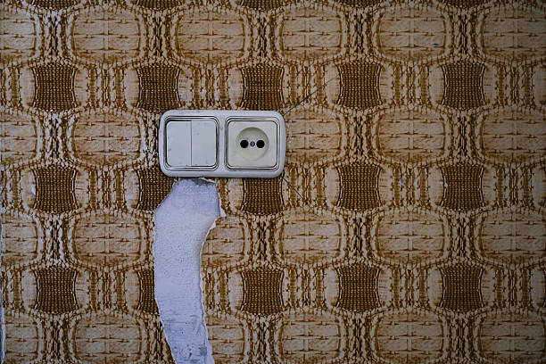 Ancienne prise et ancien interrupteur électrique sur un mur